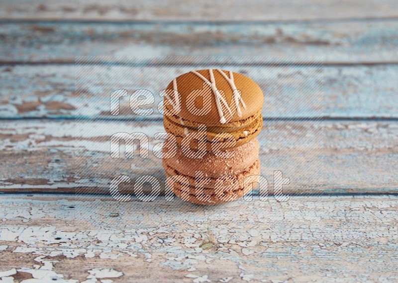 45º Shot of of two assorted Brown Irish Cream, and Brown Hazelnuts macarons  on light blue background