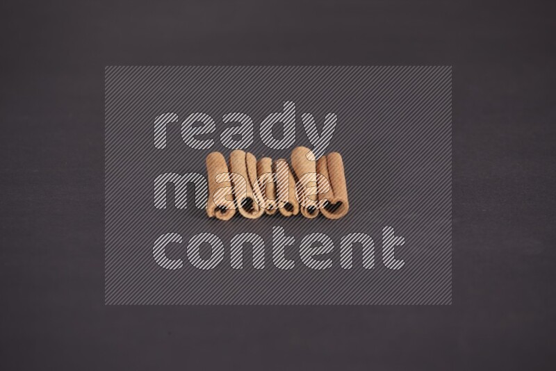 Cinnamon sticks stacked on black flooring
