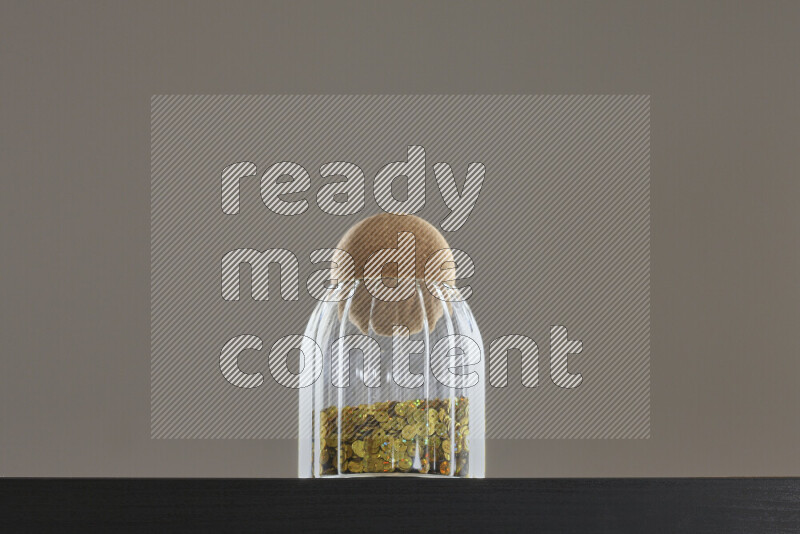 Sequins in a glass jar on black background