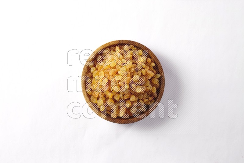 Raisins in a wooden bowl on white background