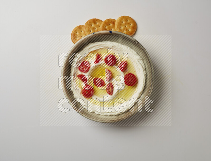 Lebnah garnished with cherry tomato in a grey pottery plate on a white background