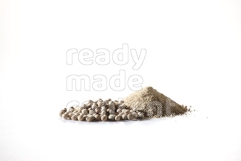 White pepper powder and pepper beads on white flooring