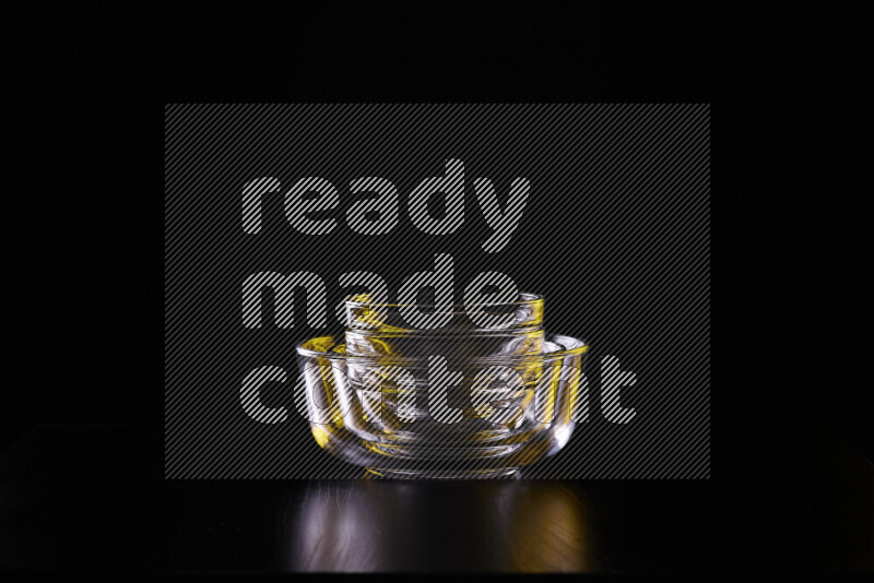 Glassware with rim light in yellow and white against black background