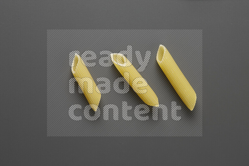 Penne pasta on grey background