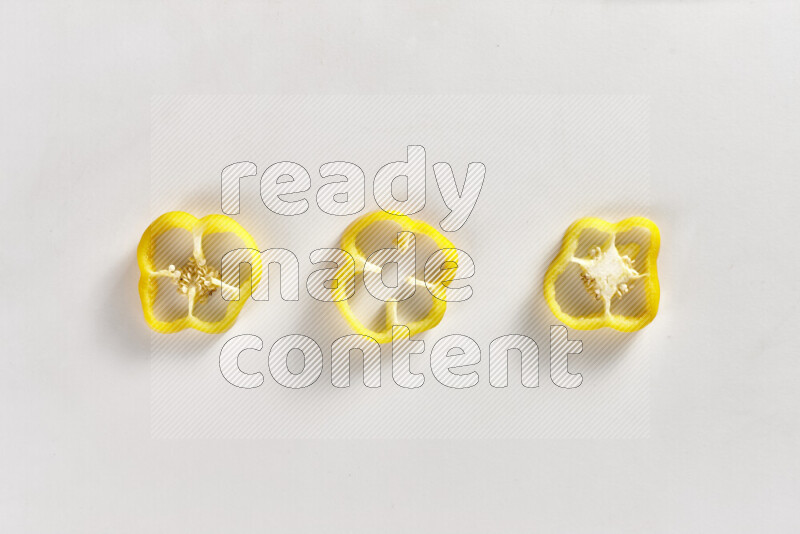 Yellow bell pepper slices on white background