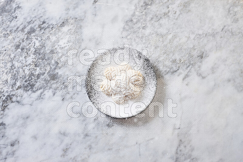 Kahk in black pottery plate on grey marble background
