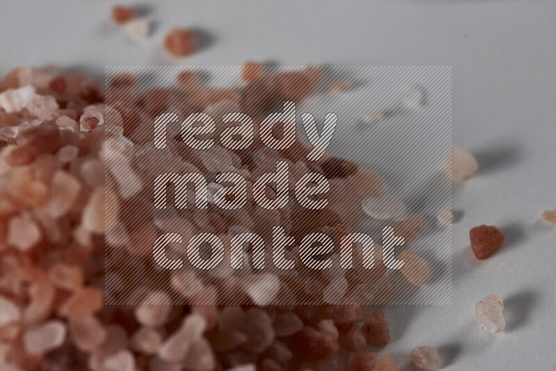 A bunch of coarse himalayan salt crystals on white background