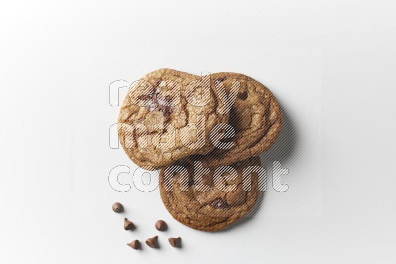 Chocolate chips cookies with chocolate beside it on a white background