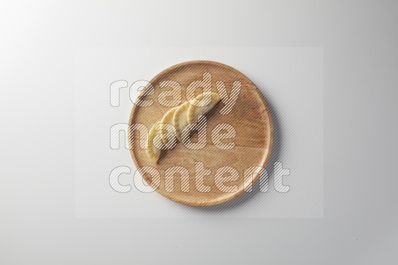 Four Sambosas on a wooden round plate on a white background
