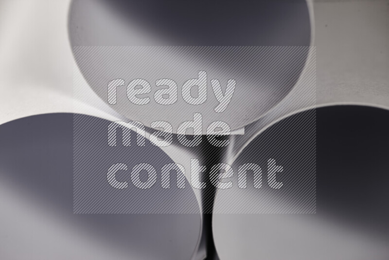 The image shows an abstract paper art with circular shapes in varying shades of grey