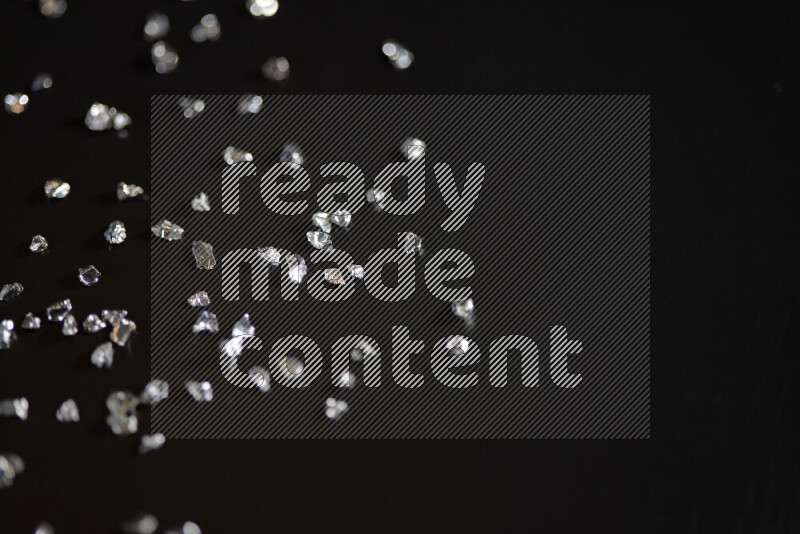 قطع زجاجية فضية لامعة متناثرة على خلفية سوداء