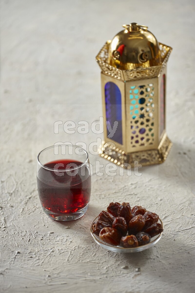 A golden lantern with different drinks, dates, nuts, prayer beads and quran on textured white background