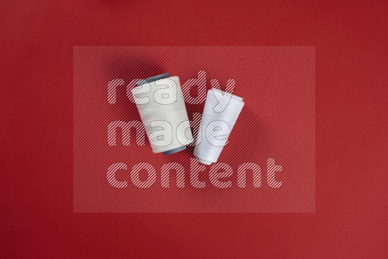 White sewing supplies on red background