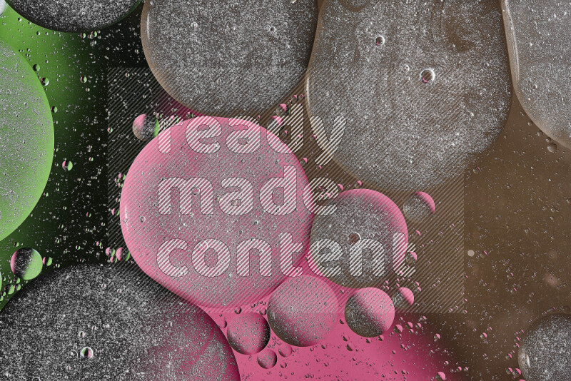 Close-ups of abstract oil bubbles on water surface in shades of brown, black, green and pink