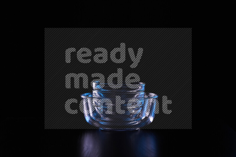 Glassware with rim light in blue and white against black background