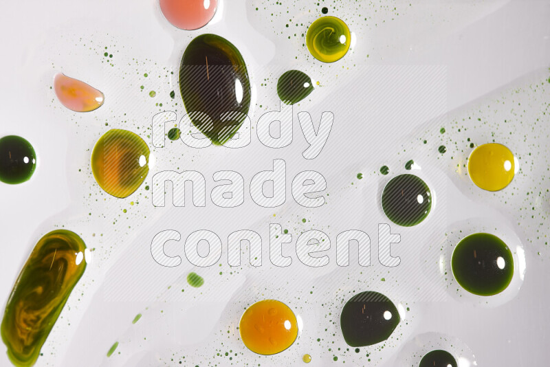 Close-ups of abstract green, yellow and red paint droplets on the surface