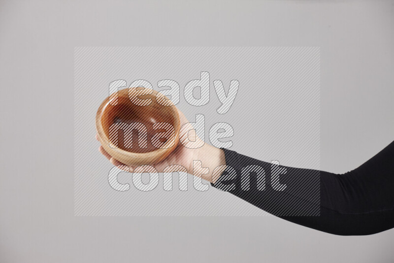 A woman in black abaya holding different wooden essentials in different positions