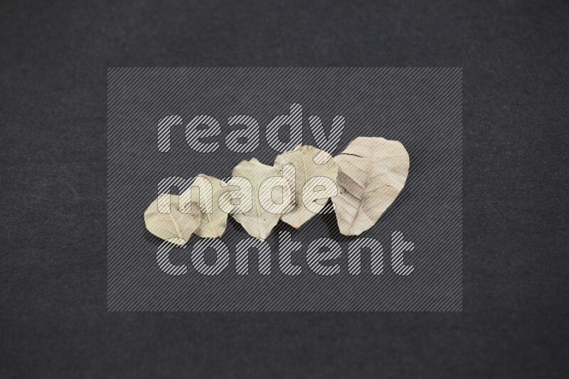 Dried bay leaves on black flooring