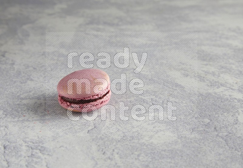 45º Shot of Purple Strawberry macaron on white  marble background