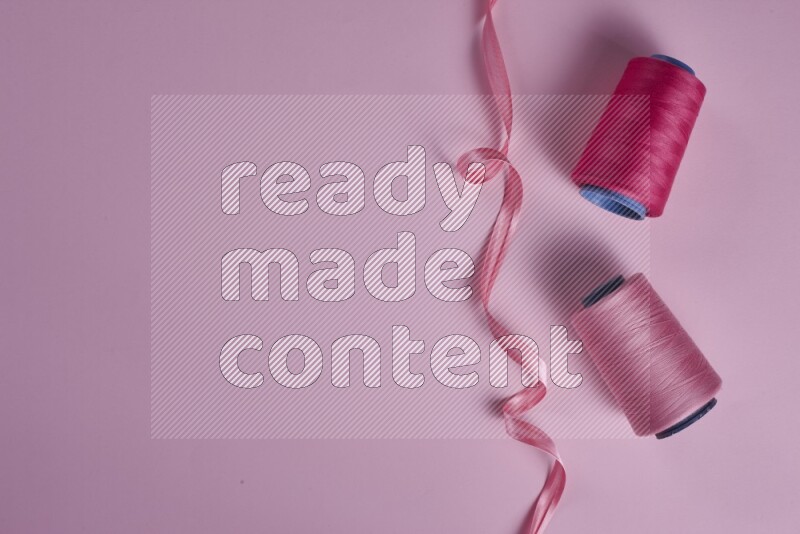 مجموعة من أدوات الخياطة والتفصيل زهرية اللون على خلفية زهرية