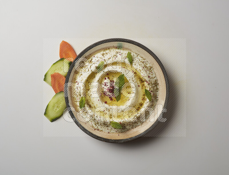 Lebnah garnished with zaater, mint & sumak in a pottery plate on a white background