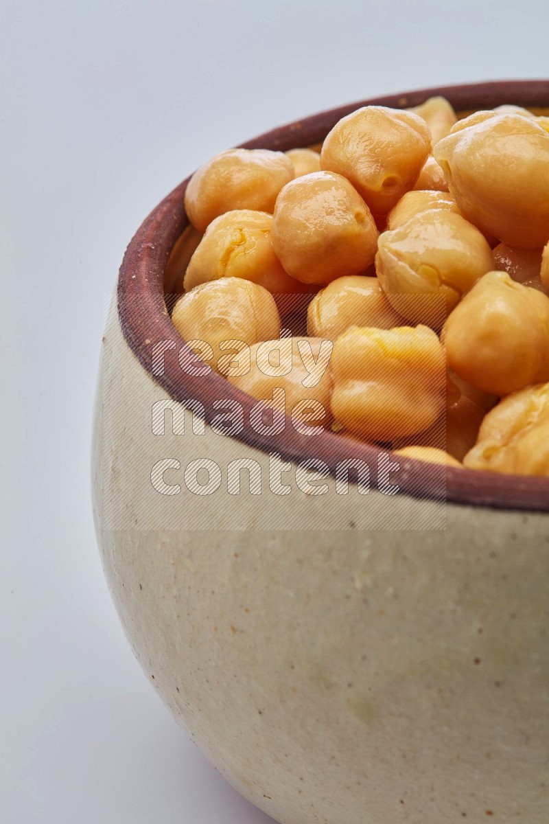 Close up shot of boiled chickpeas in a container on white background