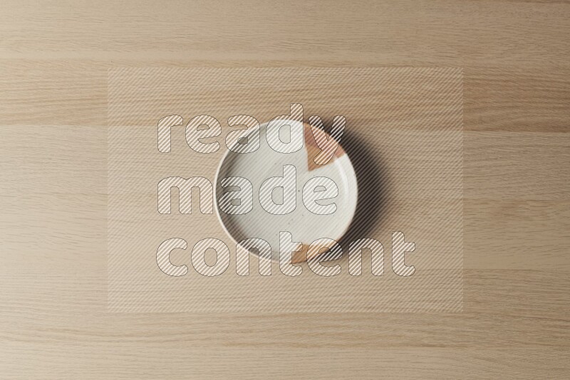 A multicolored pottery plate on light wooden background