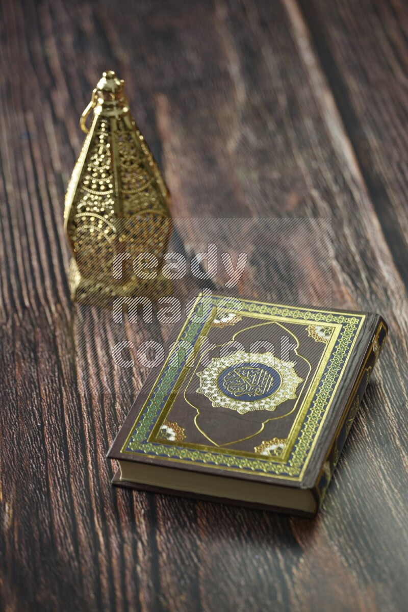 A golden lantern with different drinks, dates, nuts, prayer beads and quran on brown wooden background