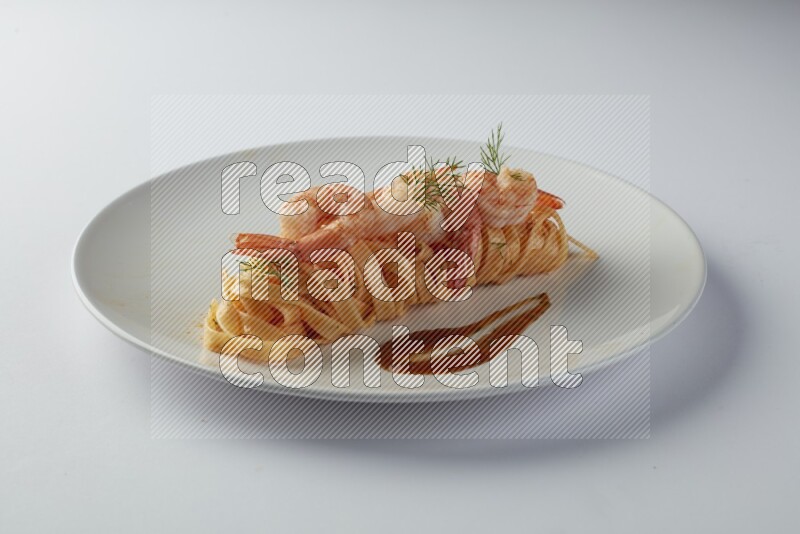 Fettuccini red sauce pasta with shrimp in a white plate on a white background