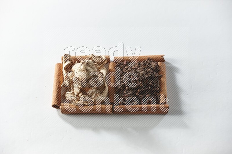 2 squares of cinnamon sticks full of cloves and dried ginger on white flooring