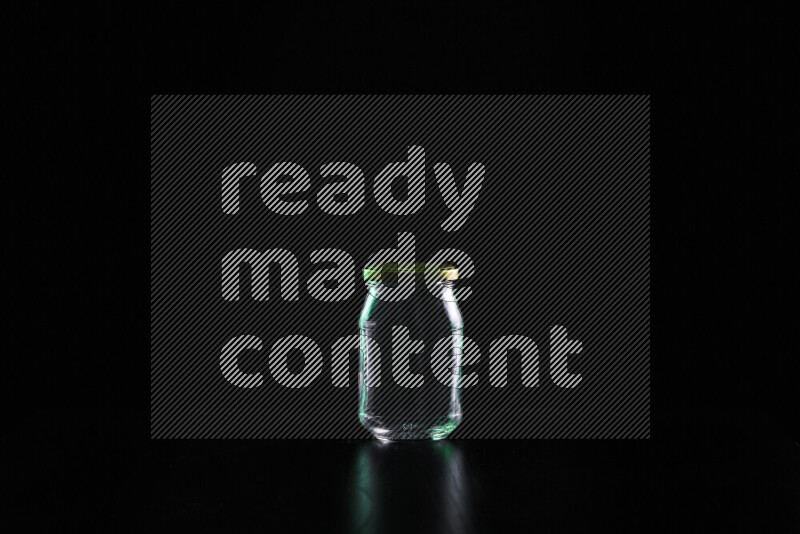 Glassware with rim light in green and white against black background