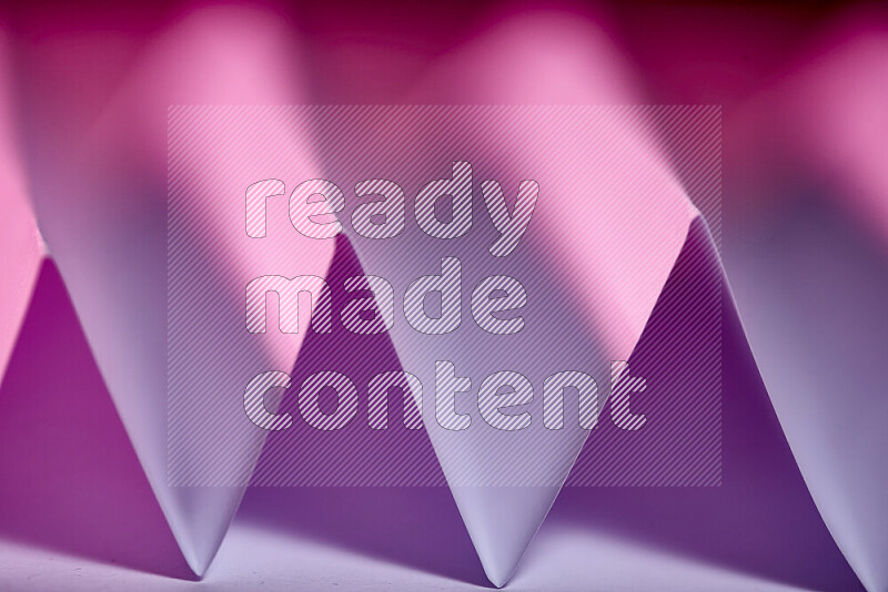 A close-up abstract image showing sharp geometric paper folds in purple gradients