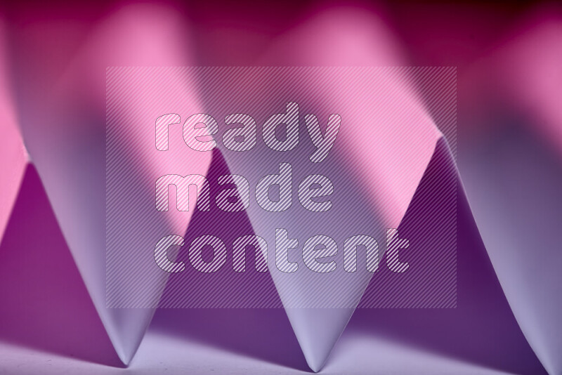 A close-up abstract image showing sharp geometric paper folds in purple gradients