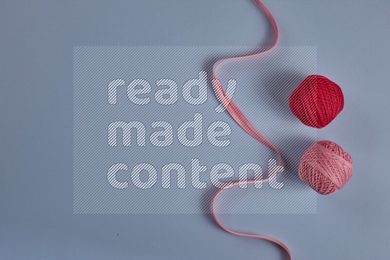 A pink collection of sewing and tailoring tools arranged on a blue background