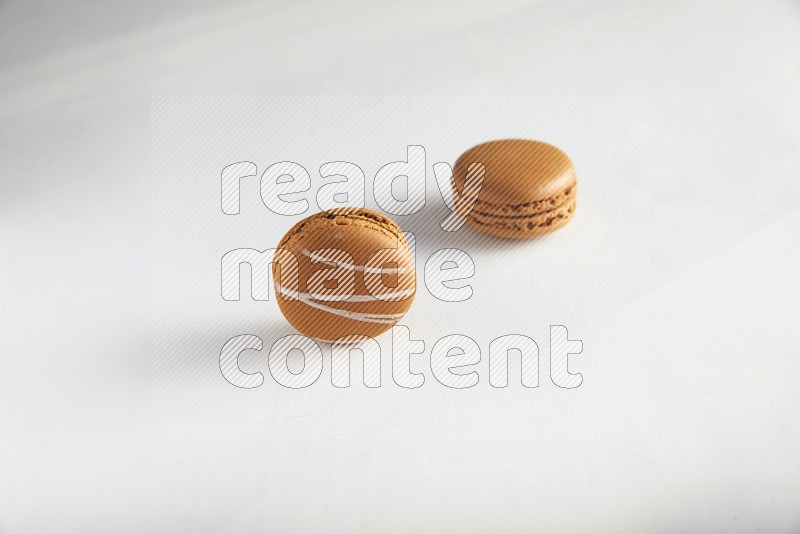 45º Shot of of two assorted Brown Irish Cream, and Brown Maple Taffy macarons  on white background