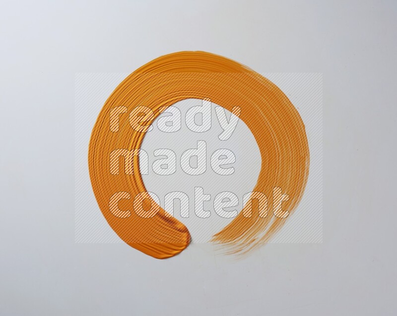 An orange circular painting brush stroke on white background
