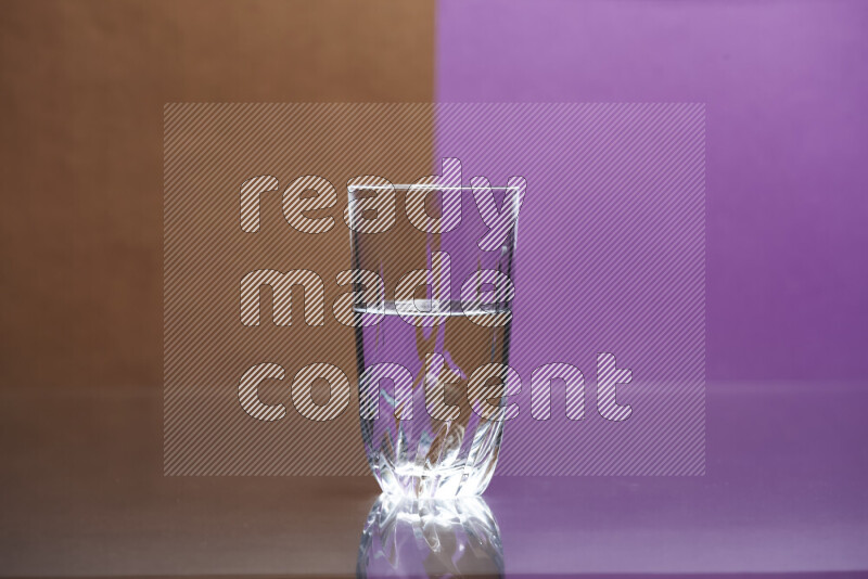 The image features a clear glassware filled with water, set against brown and purple background