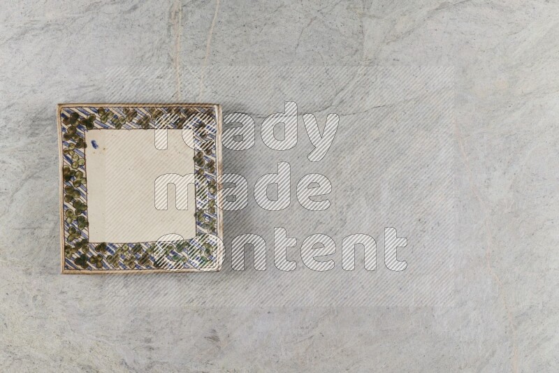 A decorative pottery plate on grey marble background