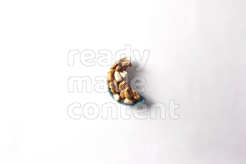 Mixed nuts in a star shaped pottery plate on white background
