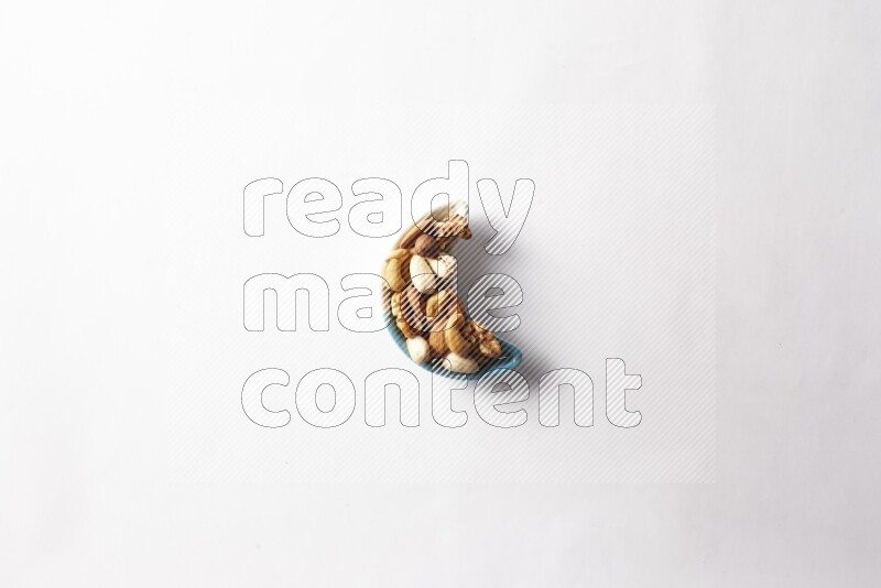 Mixed nuts in a star shaped pottery plate on white background
