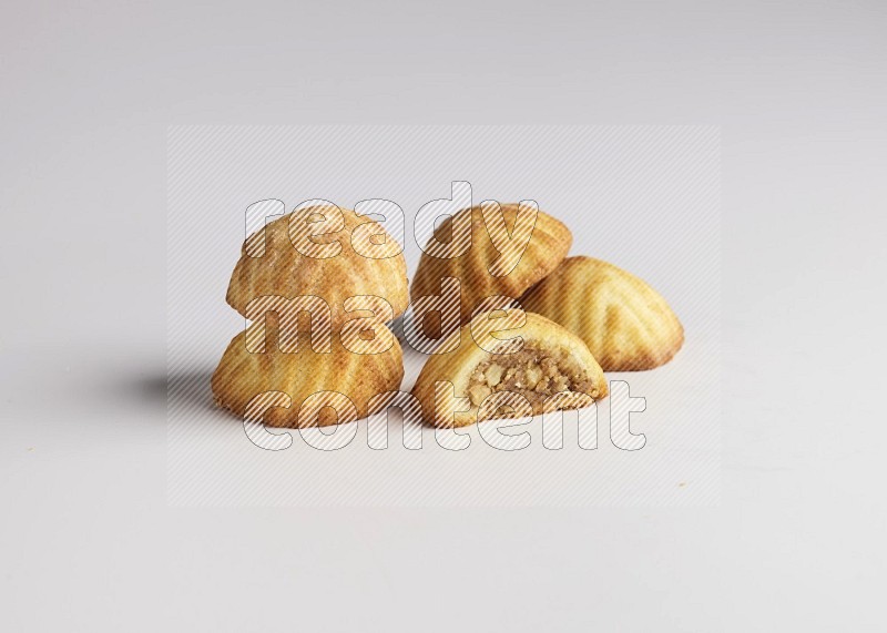 Five Pieces of Maamoul filled with walnut paste  one of them is cut with direct on white background