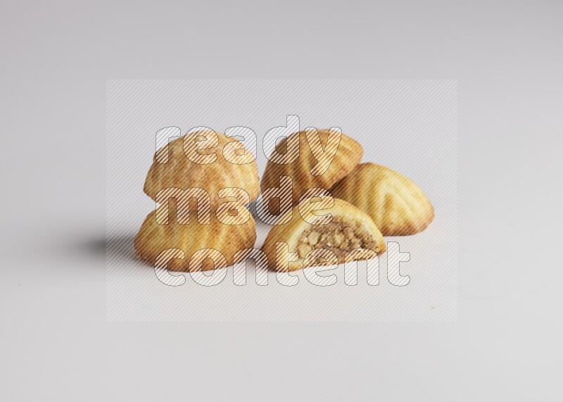 Five Pieces of Maamoul filled with walnut paste  one of them is cut with direct on white background