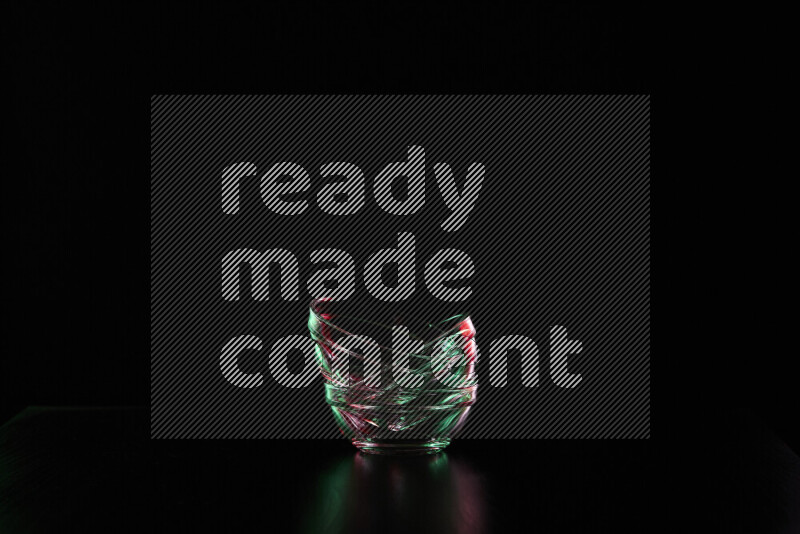 Glassware with rim light in red and green against black background