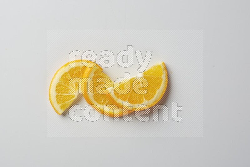Three halves of an orange slices on white background