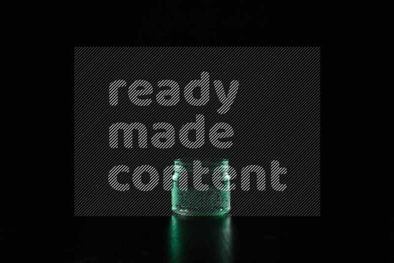 Glassware with rim light in green against black background