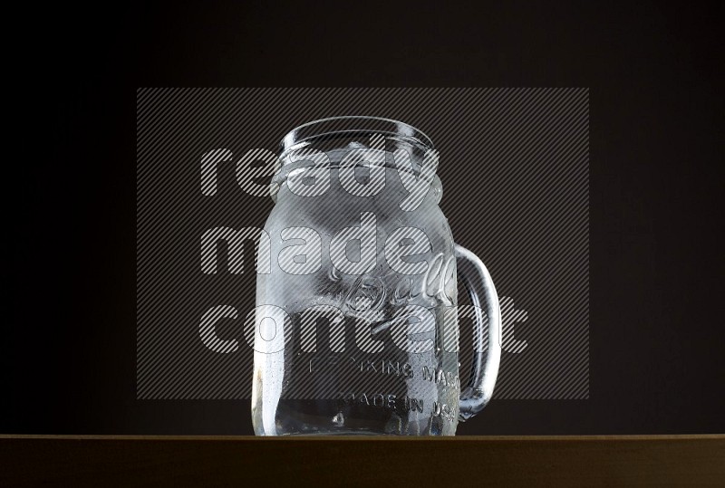 Low angle shot of a jar of water and ice on grey background