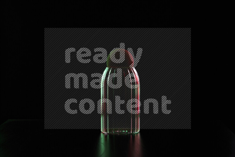 Glassware with rim light in red and green against black background