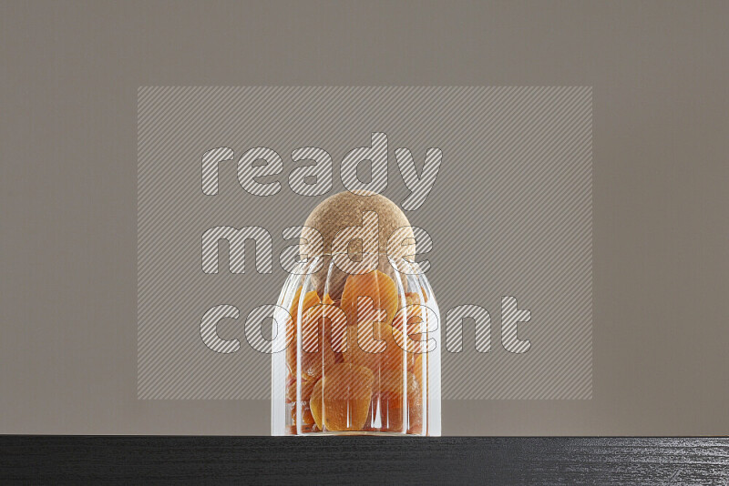 Dried apricots in a glass jar on black background