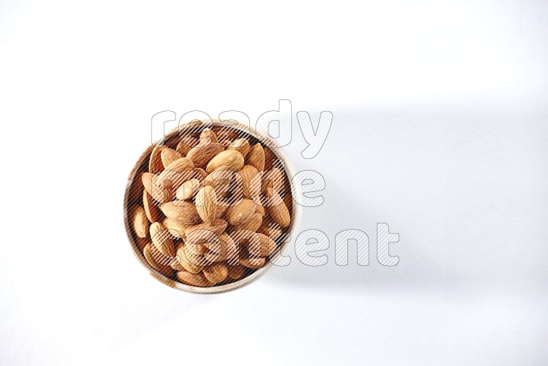 A beige ceramic bowl full of peeled almonds on a white background in different angles