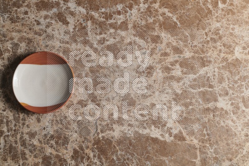 A decorative pottery plate on beige marble background
